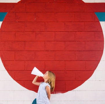 Blond Girl With Megaphone Announcing Outdoors