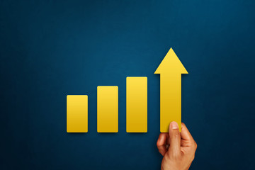 Businessman is touching arrows pointing up with graph as a symbol of growth and success or rising successful development and business development in the future