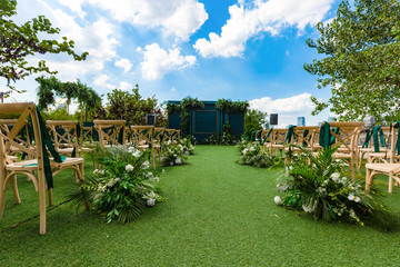 An outdoor wedding, a dessert area under a tree, with cakes and desserts on the dessert table.green gass