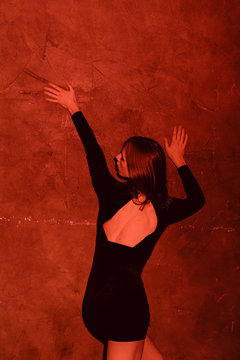 young androgyne man in small black dress dancing