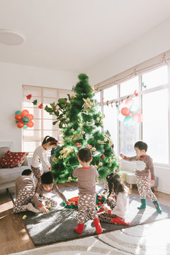 Kids decorating christmas tree at home