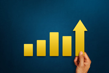 Businessman is touching arrows pointing up with graph as a symbol of growth and success or rising...