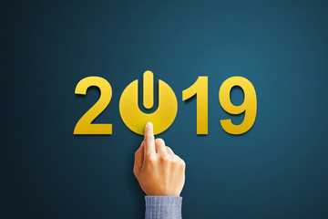 Businessman press the start button with 2019 number on blue background. Concept for success in the future goal and passing time. New Year 2019 greeting card