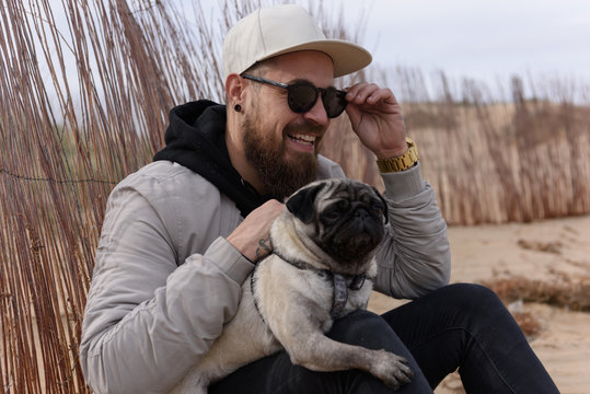 Smiling man sitting with cute pug