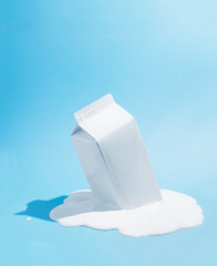 White milk carton melting on blue background