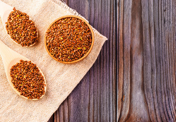 The brown flax seeds or flax seed in a small bowl on sacking