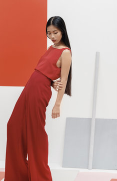 Asian fashionable female model with long hair in red in abstract space ./Fashion series