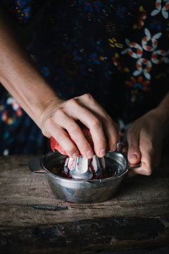 Woman squeezing fresh pomegranate halve