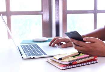 Fototapeta premium side view,business man holding smartphone .office table desk. workspace with notebook and mouse on copy space