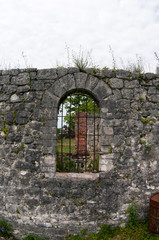 Ancient window with metal bars in a stone house.