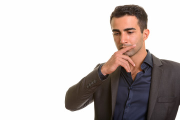 Portrait of young handsome Persian businessman against white background