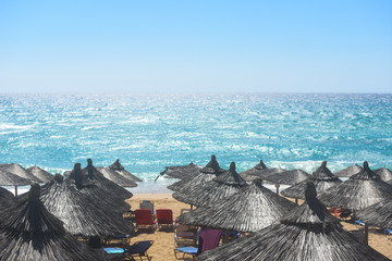 Beach umbrellas and sunbeds on Greece. Summer beach with parasols