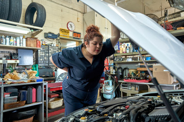 Female Mechanic Working on Cars in Her Shop