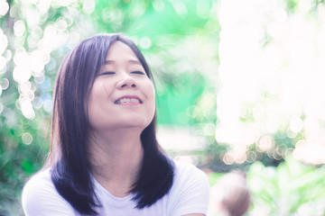 Beautiful Relax asian  Woman smiling and  enjoying in green nature background.