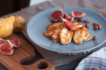 Fried slices of halloumi cheese served on the plate with fig and nut.