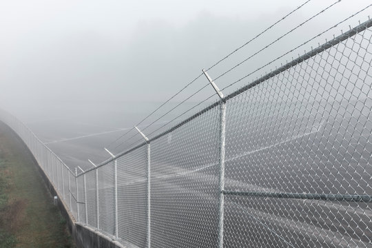 Chain-link fence topped with barbed wire