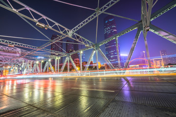 Fototapeta na wymiar car light trails on steel bridge with city skyline.