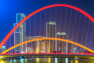 Tianjin Hai river waterfront downtown skyline with illuminated Dagu bridge,China.