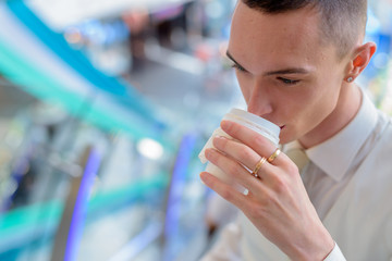 Young androgynous homosexual LGTB businessman drinking coffee