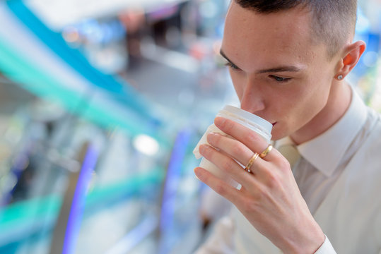 Young androgynous homosexual LGTB businessman drinking coffee - Powered by Adobe