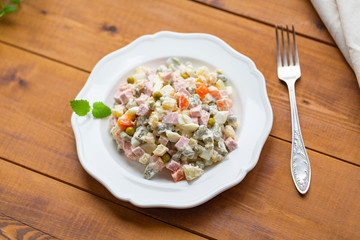 Traditional Russian salad on a wooden table