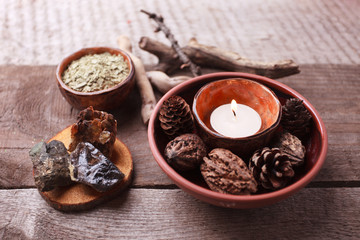 Fototapeta na wymiar Healthy herbal tea preparation with dry plants, candle, wooden and stone details and vintage rustic wooden background, monochrome, relax concept