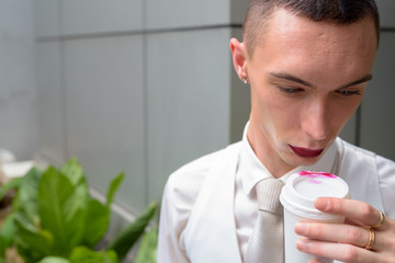 Young androgynous homosexual LGTB businessman drinking coffee