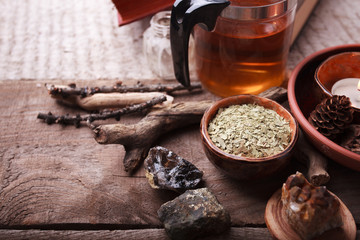 medicinal herbs, homeopathy, dried flowers, stones and glass teapot - alternative medicine, relax concept, wooden background, copy space