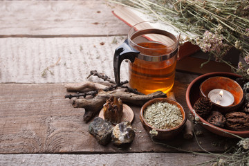 medicinal herbs, homeopathy, dried flowers, stones and glass teapot - alternative medicine, relax concept, wooden background, copy space