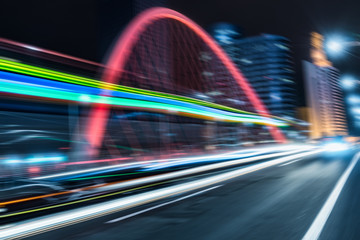 Fototapeta premium car light trails on steel bridge with city skyline.