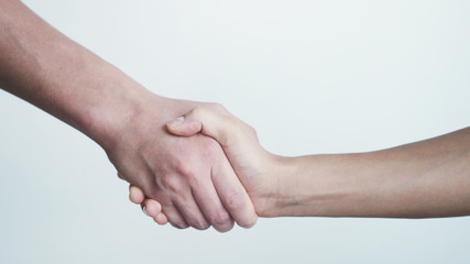 Shaking hands on white background. Close up of female and male shaking hands