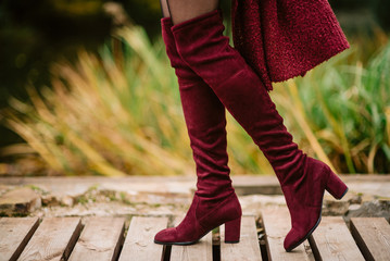 Female legs in knitted red boots. Girl in beautiful shoes outdoors