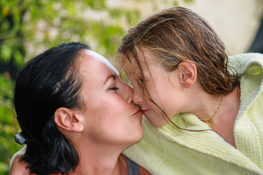Petite fille embrassant tendrement sa maman dans le jardin bisou mère et enfant plaisir et amour en famille s'embrasser liens familiaux famille heureuse et aimante petite fille 5 ans