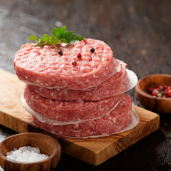 Raw Ground beef meat Burger steak cutlets  on dark wooden background.