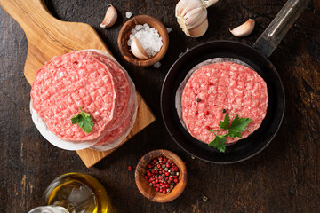 Raw Ground beef meat Burger steak cutlets  on dark wooden background.