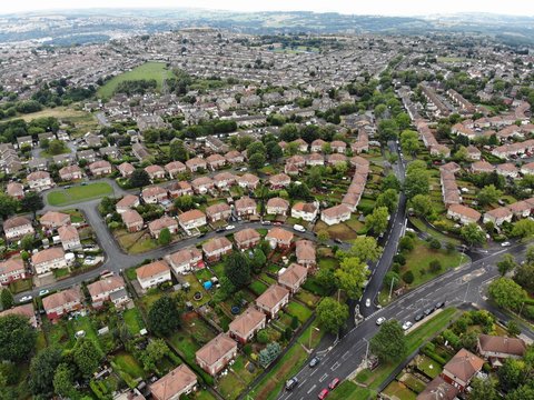 Aerial photo taken over Leeds showing houses, streets, paths and fields, taken in West Yorkshire