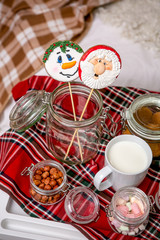Gingerbread snowman and Santa on a stick on the breakfast table in the bedroom. Holiday sweets. New Year and Christmas theme. Festive mood