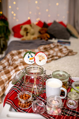 Gingerbread snowman and Santa on a stick on the breakfast table in the bedroom. Holiday sweets. New Year and Christmas theme. Festive mood