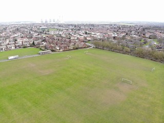 Aerial photo taken over Leeds showing houses, streets, paths and fields, taken in West Yorkshire