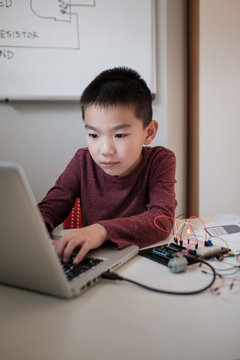 Boy working on an electronic DIY kit at home