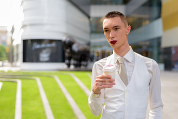 Young androgynous homosexual LGTB businessman drinking coffee