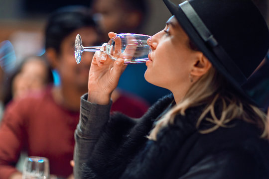 Woman drinking wine during a wine tasting event with friends