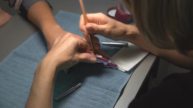 Professional Manicurist works on nail of client in beauty saloon. Nail extension by gel lacquer and polishing. Close up. 1080p