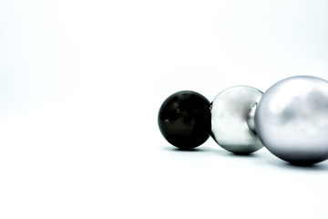 White, black and silver christmas balls on white.