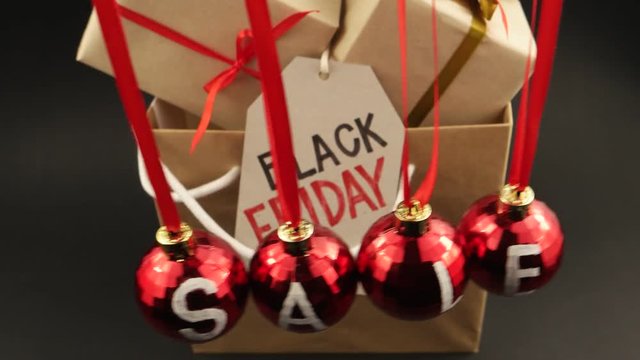 Four red balls with the word sale, written on them, swinging against the black background, Black Friday 