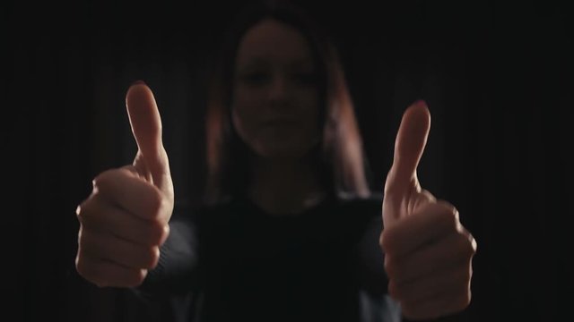 Young girl giving double thumps up.