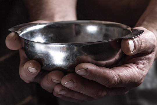 Feeding the poor to hands of a beggar. Helping poor people in need. The concept of hunger or poverty. Alms