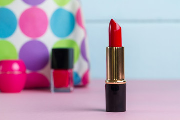 Red lipstick on a pink table on a blue background