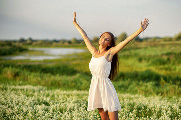 Happy  and serene behavior woman  outdoor with raised hands.