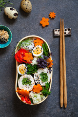 Japanese bento box with chicken stuffed with asparagus, rice, vegetables and quail eggs
